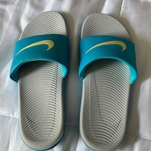 Like new Womens size 9 Nike slides. Teal with yellow swoosh. Never worn outside.